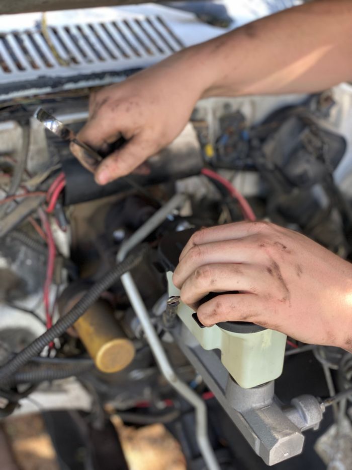 Home Close-up of a mechanic's hands repairing a car engine with tools and expertise.