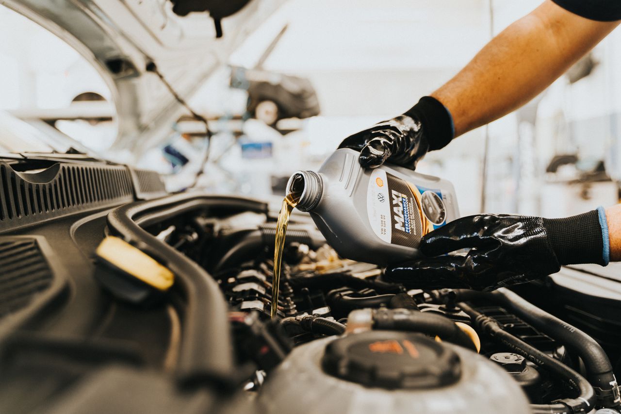 The Art of Drawing Readers In: Your attractive post title goes here Close-up of a mechanic pouring engine oil into a car engine in an auto repair shop.